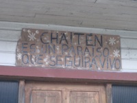 Over one house's front door: "Chaitén is a paradise that will continue to live."